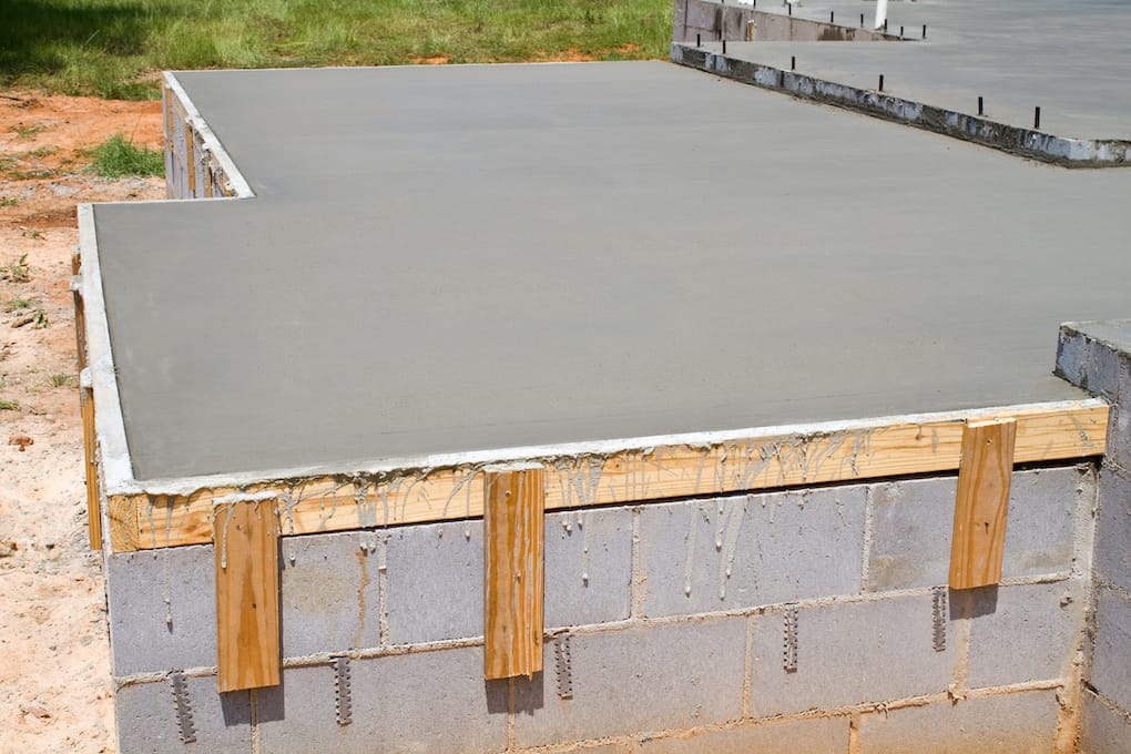 New construction of a freshly poured concrete slab floor on a residential home during concrete cure time