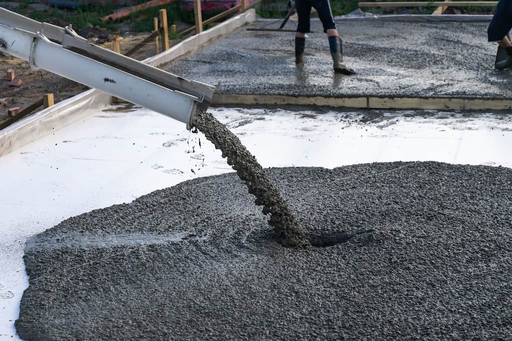 Workers pour the Foundation for the construction of a residential building using mobile concrete roading materials mixers