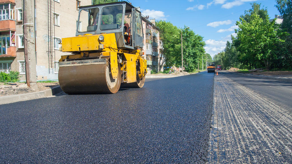 roller compacting asphalt roading materials for parking lot