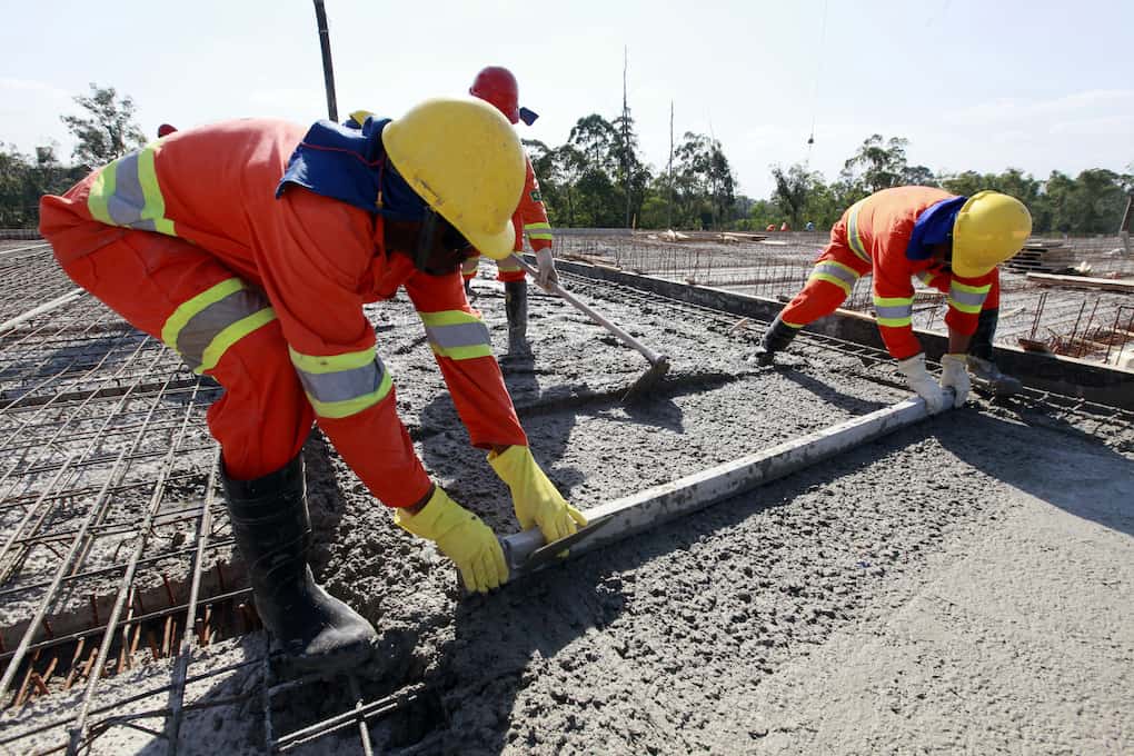 workers pouring cement in road construction