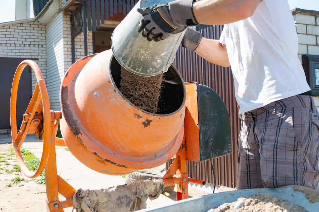 worker using machine to mix types of concrete